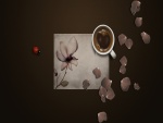 Una mariquita y pétalos de flor junto a una taza de café