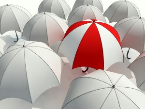 Postal: Paraguas rojo y blanco entre varios paraguas blancos