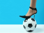 Zapato de tacón sobre un balón de fútbol