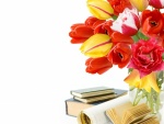Libros junto a un jarrón con tulipanes