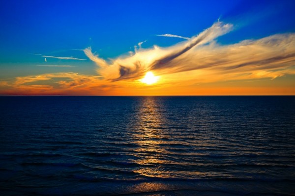 Puesta de sol en el horizonte iluminando las aguas del océano