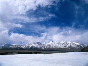 Postal: Un lago helado junto a las montañas