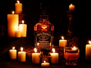 Postal: Botella de Jack Daniel's entre velas encendidas