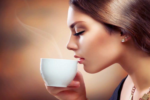 Una bella mujer tomando café