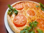 Pizza con rodajas de tomate y perejil