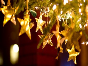 Estrellas doradas y luces en el árbol de Navidad