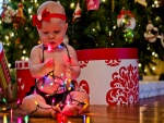 Una bebé cubierta de luces de Navidad