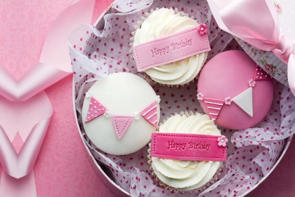 Feliz cumpleaños con cupcakes decorados en color rosa y blanco