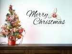 Pequeño árbol decorado y Feliz Navidad