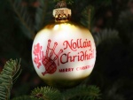 "Feliz Navidad" escrito en una bola colgada del árbol