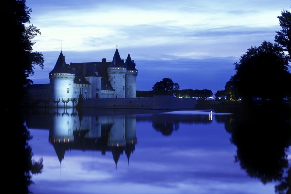 Castillo reflejado en el agua al anochecer