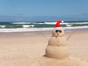 Muñeco navideño de arena en una playa