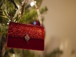 Un bolso rojo brillante colgado del árbol de Navidad
