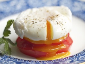Un huevo poché sobre rodajas de tomate