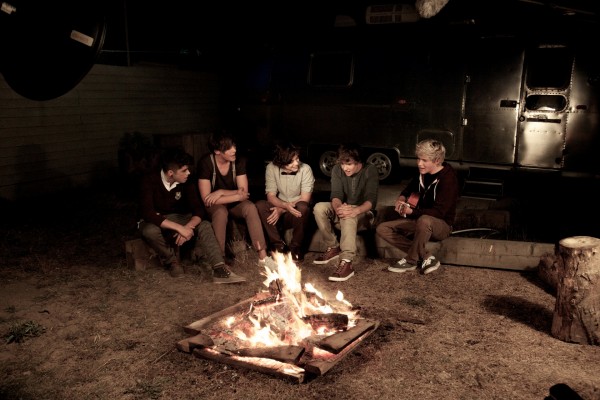 Los chicos de "One Direction" cantando junto a una hoguera