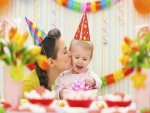 Una madre besando a su bebé en la fiesta cumpleaños