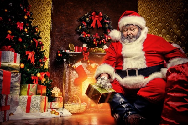 Papá Noel junto al pino y los regalos de Navidad