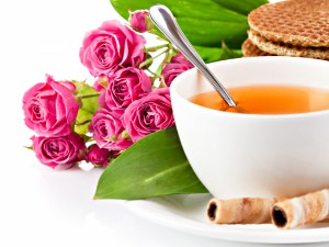 Rosas junto a una taza de té