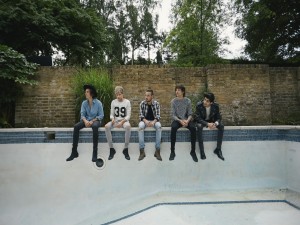 Los chicos de "One Direction" en el bordillo de una piscina