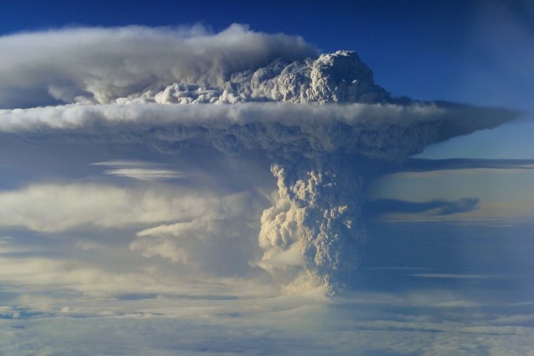 Densa columna de humo emanando de un volcán en erupción