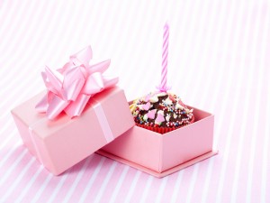 Cupcake con una vela en una cajita rosa de regalo