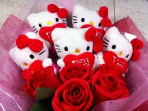 Postal: Muñecas de Hello Kitty en un ramo con rosas rojas