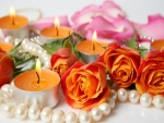 Velas encendidas y rosas naranjas