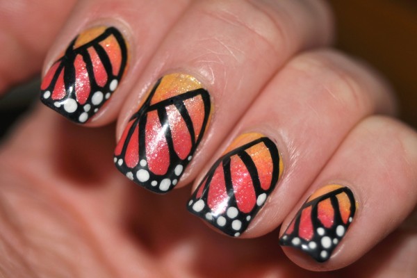 Uñas pintadas con los colores de la mariposa monarca