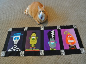 Postal: Gato junto a una tela decorada para Halloween