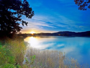 El sol al amanecer reflejado en el lago