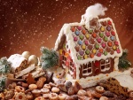 Galletas y otros dulces navideños junto a una casa de galleta
