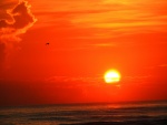 El sol en un cielo naranja sobre el mar