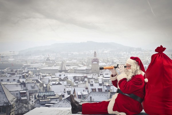 Santa Claus observando una ciudad sentado en un tejado