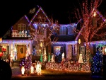 Luces de Navidad iluminando la casa y las figuras