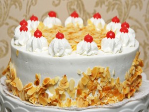 Una rica tarta cubierta de nata y almendras
