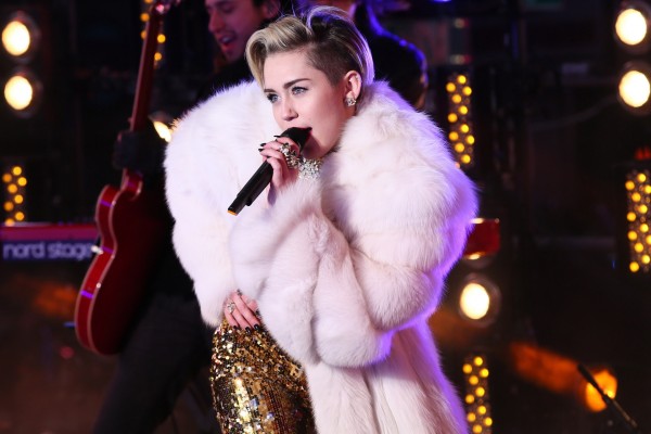 Miley Cyrus en un concierto con un bonito abrigo blanco