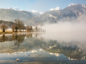 Postal: Niebla sobre un lago de aguas transparentes