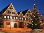 Árbol de Navidad iluminado frente a una hermosa casa