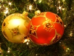 Una bola naranja y otra amarilla decorando el árbol de Navidad