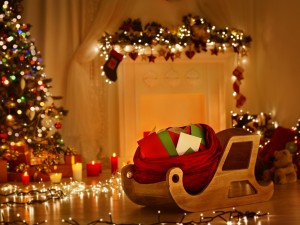 Regalos sobre un trineo de madera junto a un árbol de Navidad