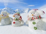 Tres simpáticos muñecos de nieve en la montaña