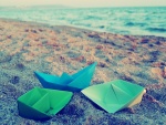 Barcos de papel sobre la arena de una playa