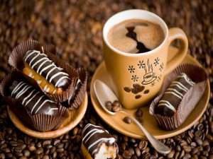Taza de café acompañado de pasteles de chocolate