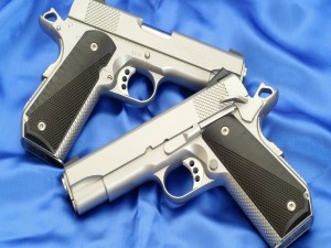 Dos pistolas plateadas sobre una sábana azul