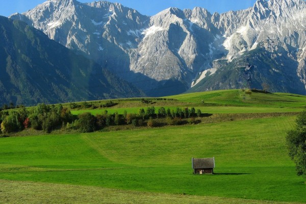 Vista de una cabaña en el valle verde