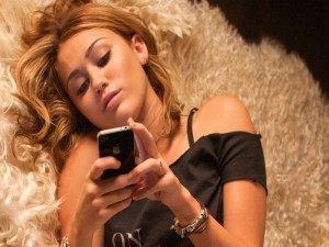 La cantante y actriz Miley Cyrus mirando su móvil