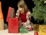 Asombro y sorpresa de una niña al abrir su regalo de Navidad