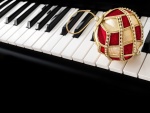 Bola dorada y roja sobre las teclas de un piano