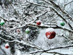 Árbol y bolas navideñas cubiertos de copos de nieve