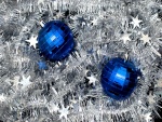 Dos bolas azules sobre espumillón de Navidad